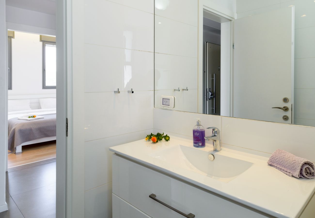 Clean bathroom in Tel Aviv apartment  Modern white sink with big mirror on Ben Yehuda st.